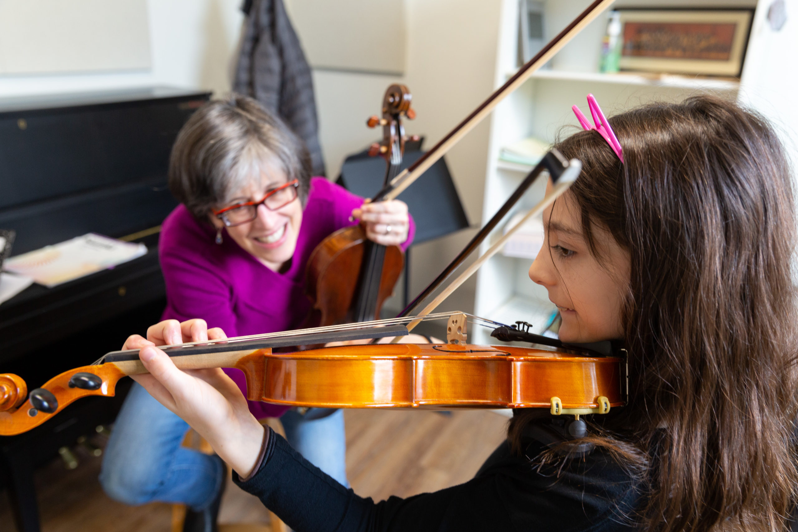 Faculty member teaching a young student violin in a private lesson