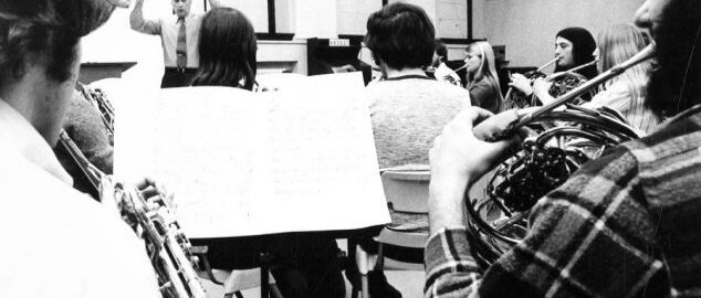 Verne Reynolds conducts the Eastman Horn Choir, viewed from the 2nd row of musicians.