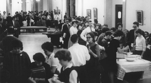 Several dozen students mingle during a reception in Cominsky Promenade.
