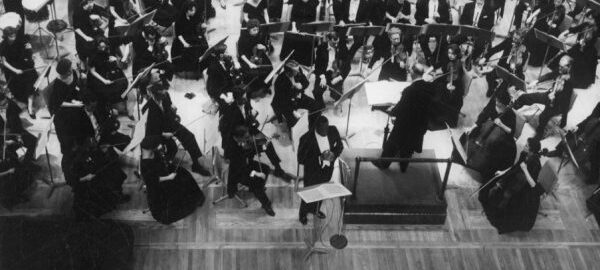 William Warfield and the Eastman Philharmonia at a performance during their 1961 Washington, DC, tour. Photograph from ESPA 6/54 (8x10). Overhead view of William Warfield performing on stage with the Eastman Philharmonia at a Washington D C concert.