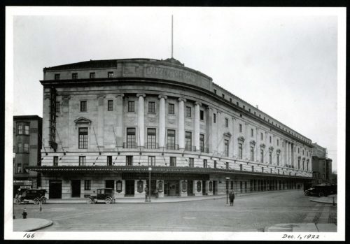 Photograph from ESPA Album 7/16. Black and white photo of the exterior of Eastman Theatre, viewed from the northwest corner of Main Street and Gibbs Street (1922).