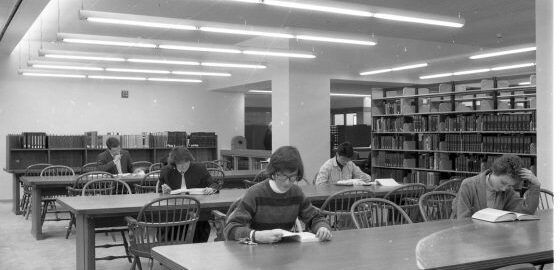 Black and white photo of the second-floor reading room in the new Sibley Music Library, showing five students studying at long tables.