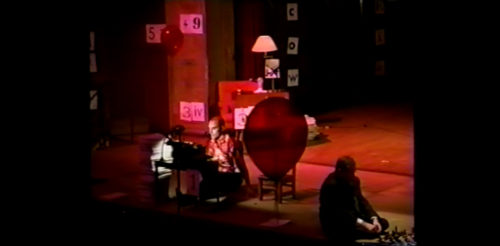 Part I at 29-03 having moved the chair aside, performer begins to lower himself