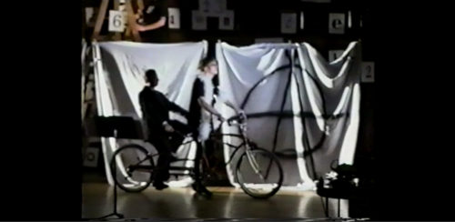 Part II at 18-38 two performers re-entering the stage, this time together on a tandem bicycle