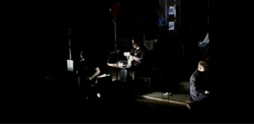 Part II at 34-48 the codex-carrying performer chewing gum while the other is making something at the desk