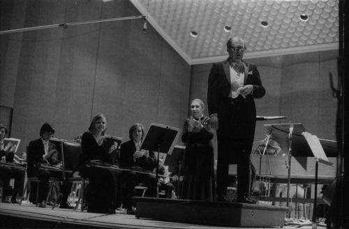 R1397-20 Eastman Philharmonia concert that featured the premiere of Krzystof Penderecki’s Partita for Harpsichord and Orchestra. At the conclusion of the Partita, Maestro Hendl invites the composer to the stage for bows. In the last shot, the composer, the soloist, and the conductor all join hands to acknowledge the applause.