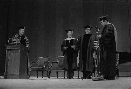 R1410-6 Conferral of an honorary doctoral degree on Shinichi Suzuki. Professor Donald Shetler hoods the newly named Dr. Suzuki; University President Robert Sproull stands at far left, and ESM Director Walter Hendl stands at far right.