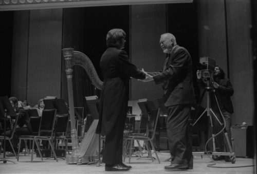R1486-29A Howard Hanson greets Donald Hunsberger and acknowledges the audience’s applause on the occasion of the Eastman Wind Ensemble’s premiere performance of his Dies Natalis II, April 7th, 1972.