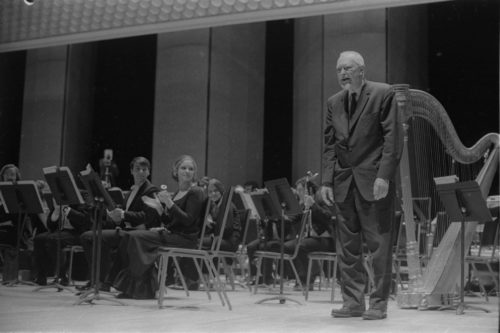 R1486-31A Howard Hanson greets Donald Hunsberger and acknowledges the audience’s applause on the occasion of the Eastman Wind Ensemble’s premiere performance of his Dies Natalis II, April 7th, 1972.