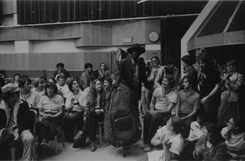 R2891-2A Ron Carter arriving in Room 120, double bass in hand.