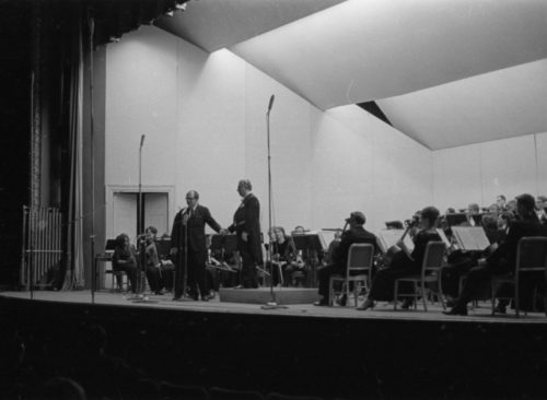 Eastman School Director Walter Hendl introducing guest composer-conductor Aram Khachaturian, and Mr. Khachaturian’s assistant, Mr. Joseph Zarovich, translating the composer’s comments for the audience.