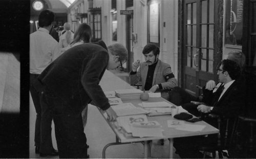 R742-20 An information center set up in the main hall. The young man at center (seated) is wearing the black armband that was one of the symbols promoted on the day of the Moratorium.