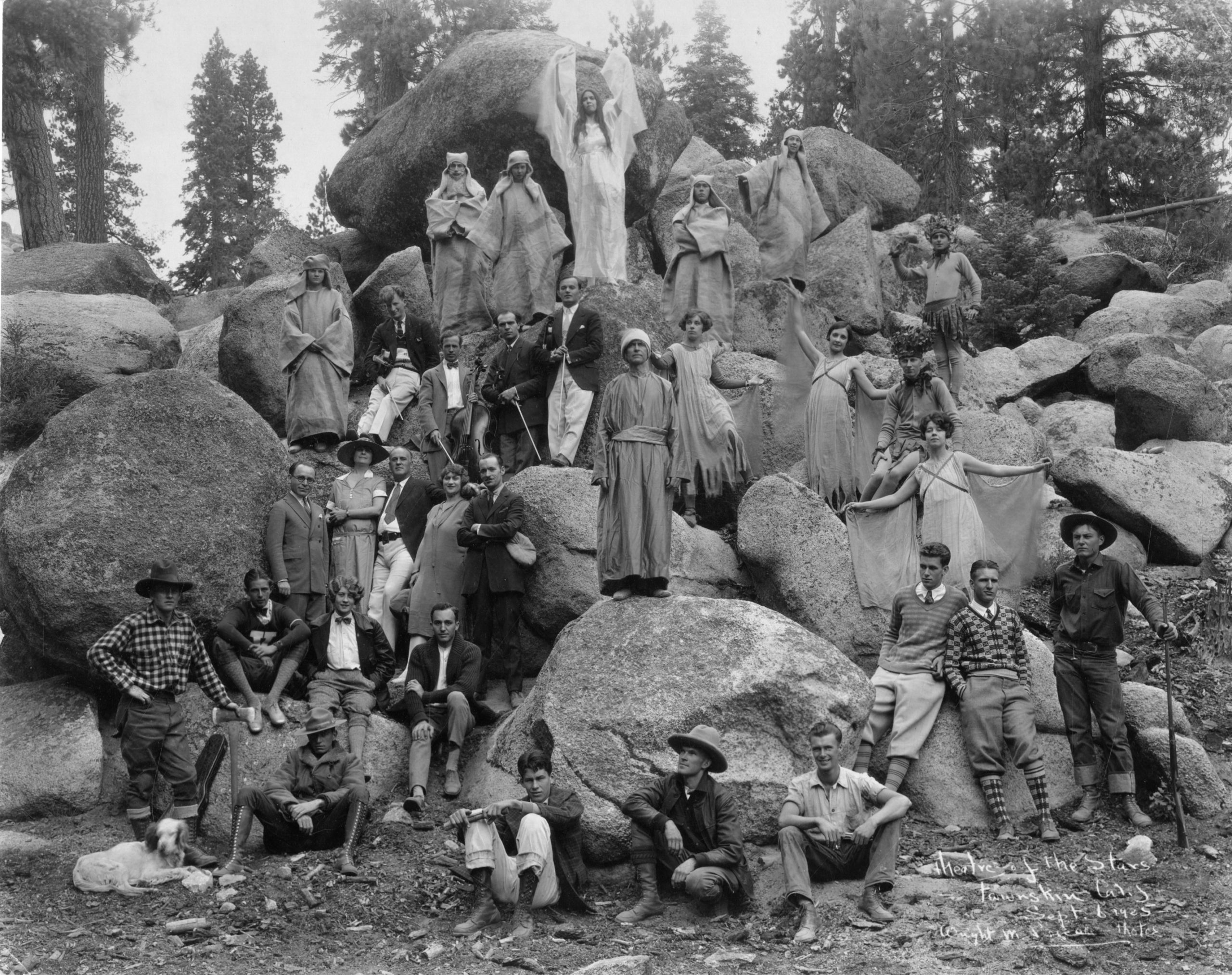 Cast of The March of Man, posing on a wall of boulders. Cast of The March of Man, posing on a wall of boulders.