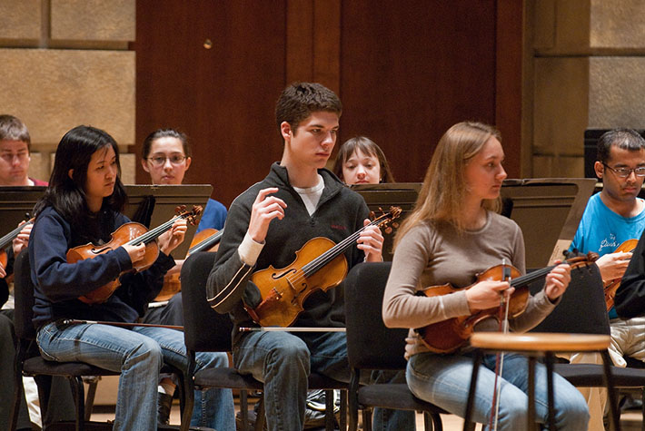 String players in the Eastman Chamber Orchestra practice a new technique for performing baroque music.
