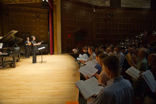 Students singing with conductor Students singing with conductor