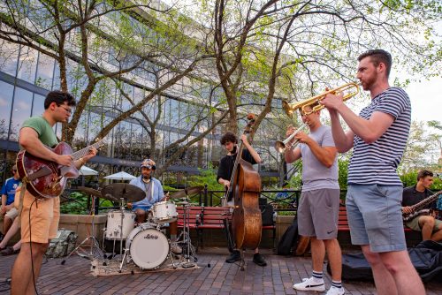 5 students playing music in atrium garden