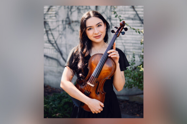 woman in black dress, standing outside, holding a viola