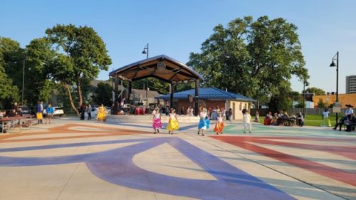 Young dancers in colorful skirts on outdoor stage