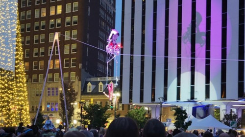 Spectators view a highwire performer on a motorcycle