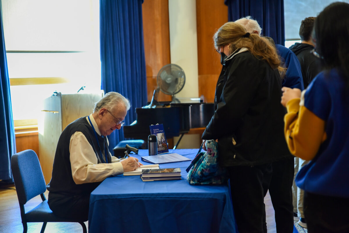 Lenti signs copies of âNurturing the Love of Music,â the third book in his history of Eastman